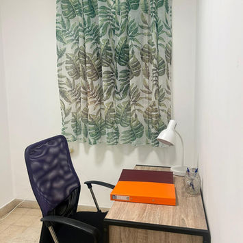 Рабочий стол с фиолетовым креслом, лампой и шторами с листьями