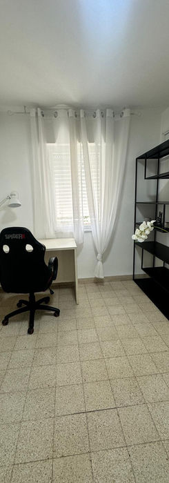 Рабочий кабинет со столом, креслом и стеллажом у окна