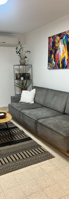 Современная гостиная с серым диваном и яркой картиной