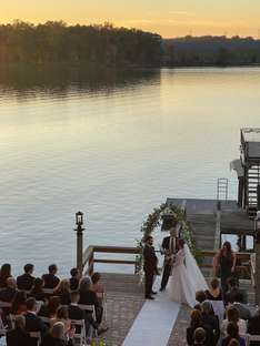 A bride and groom standing on a dock getting married