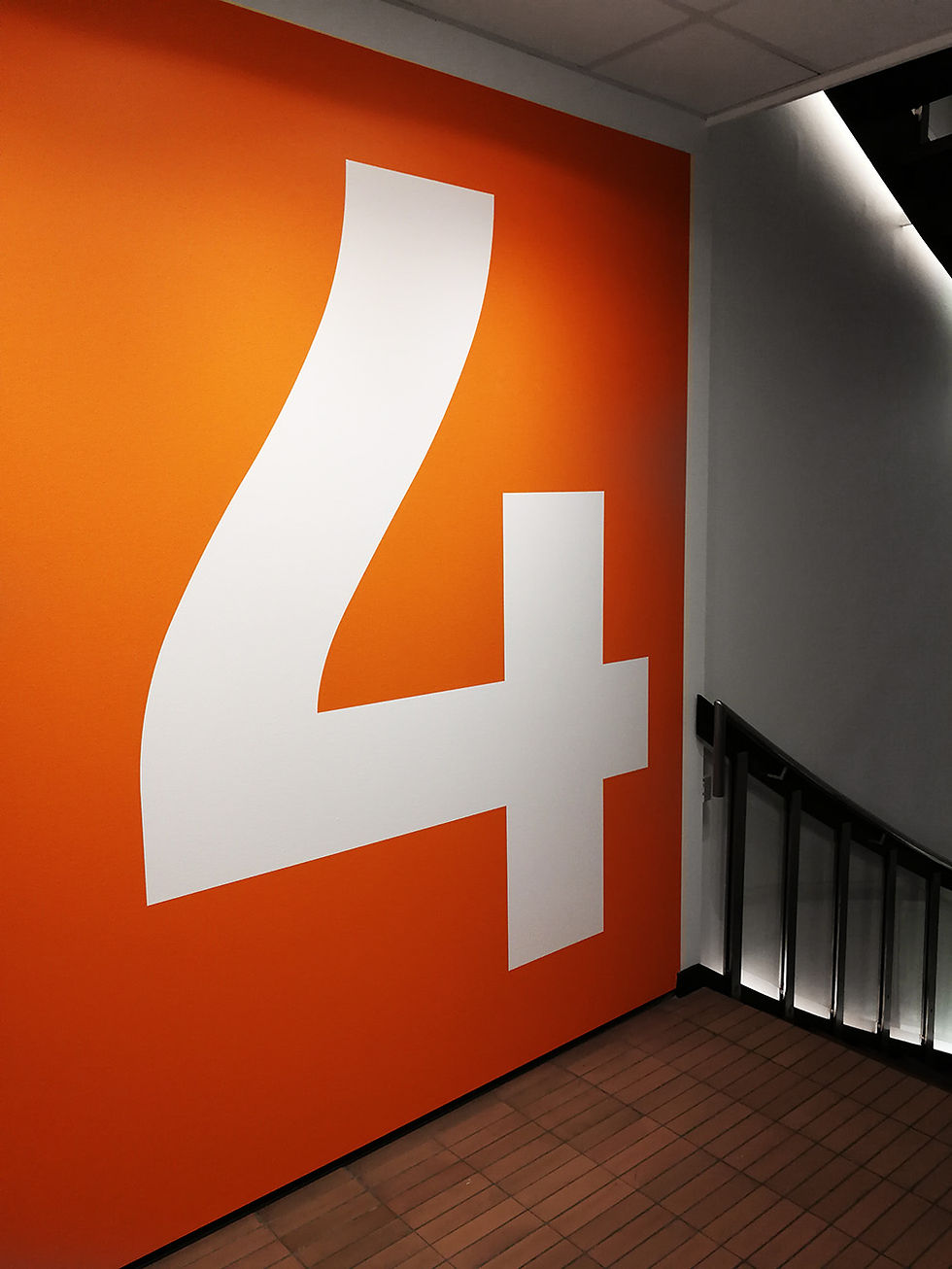 Stort 4 tal på orange baggrund lavet i folie på en etage