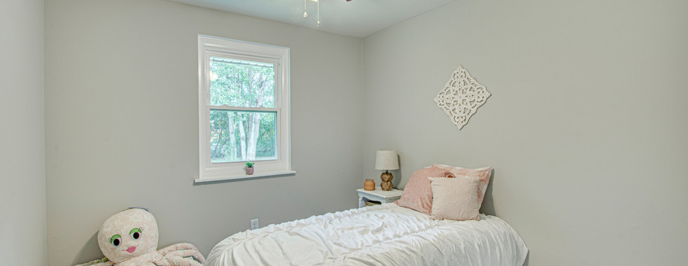 Another bedroom has a bed and toy chest.