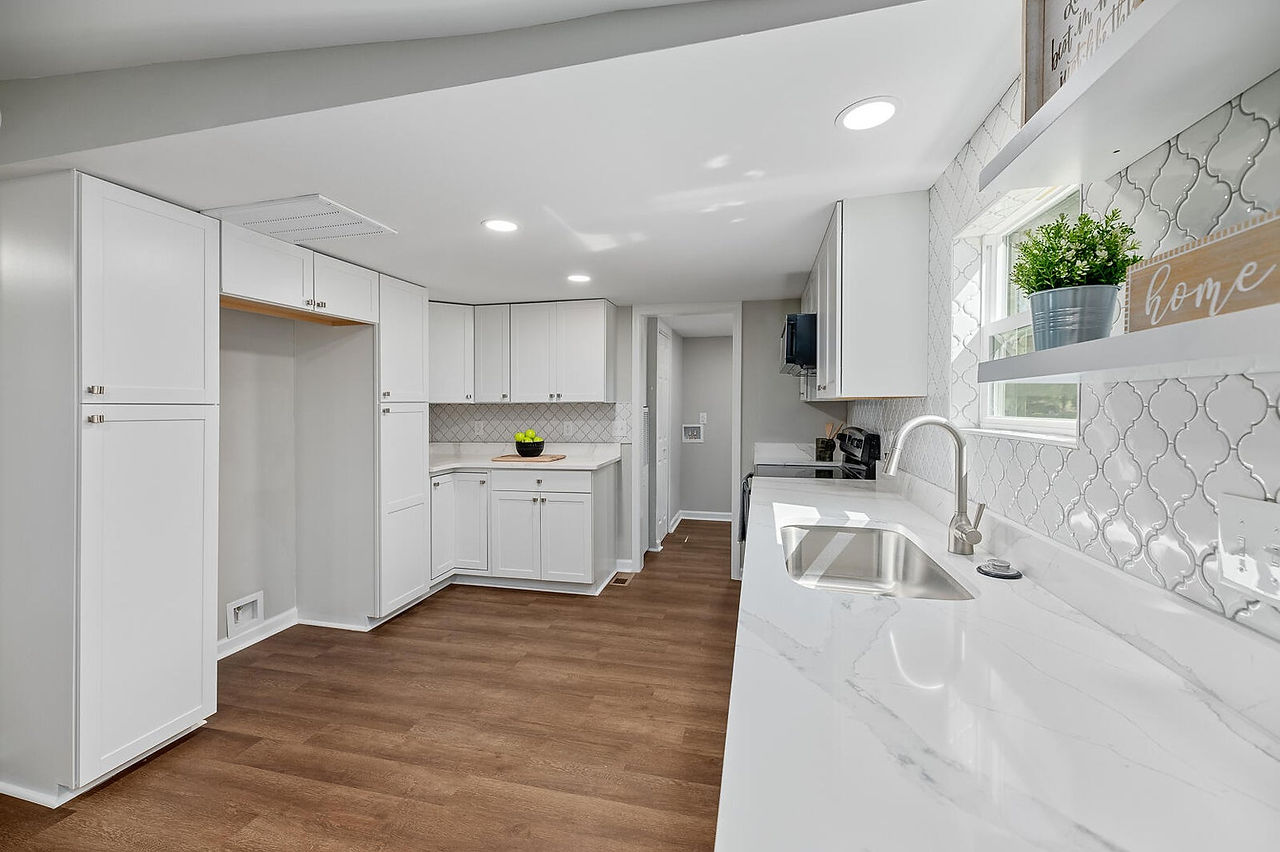 Another view of the kitchen that shows the cabinet storage and tile backsplash.