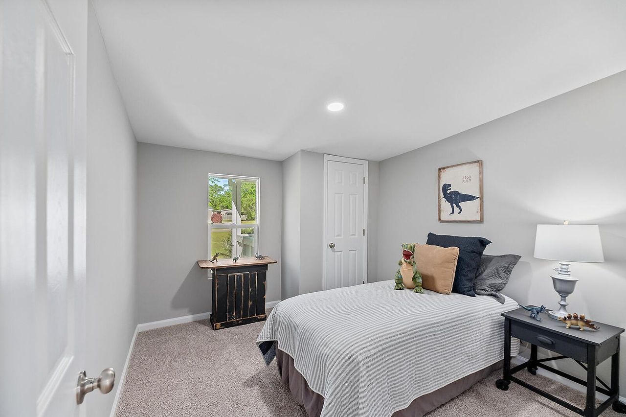 Another bedroom in the home also has carpet and light gray walls.
