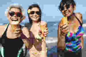 A group of senior women are enjoying the sun by keeping cool in fresh water and having fun eating ice cream. That's how you keep cool while keeping cool ;)