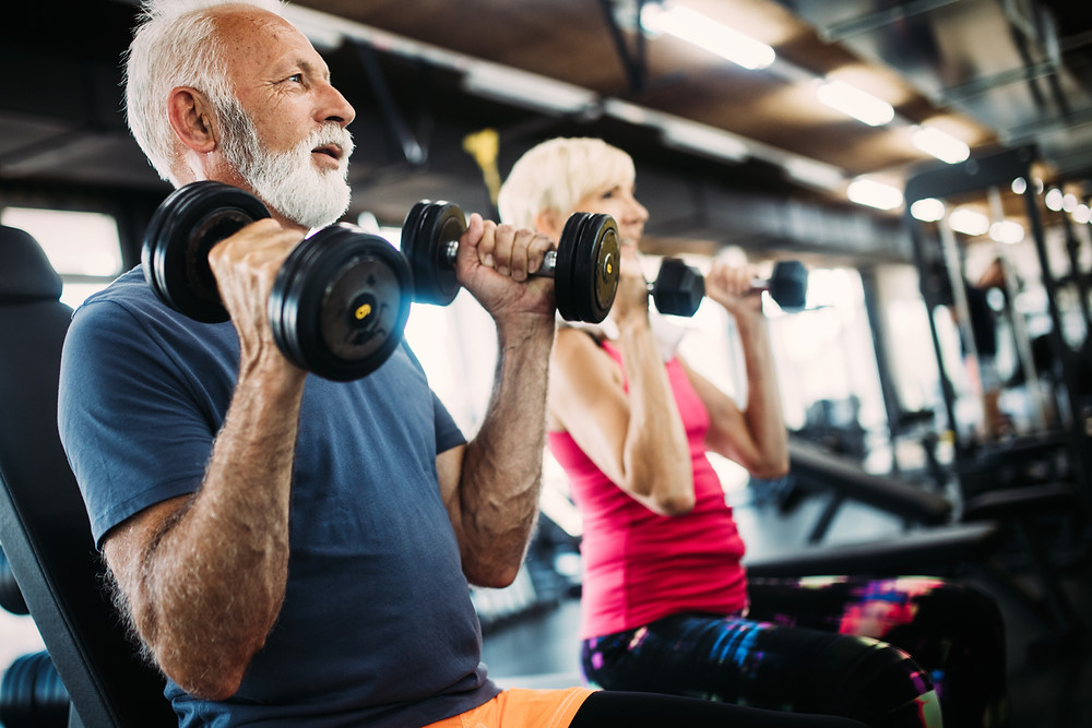 Two senior citizen utilize free weights for exercise in order to improve their brain health and reduce cognitive decline.