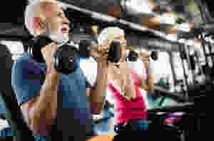 Two senior citizen utilize free weights for exercise in order to improve their brain health and reduce cognitive decline.
