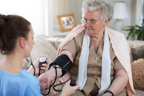 Home Health Care Nurse checking blood pressure of senior medicare insured patient
