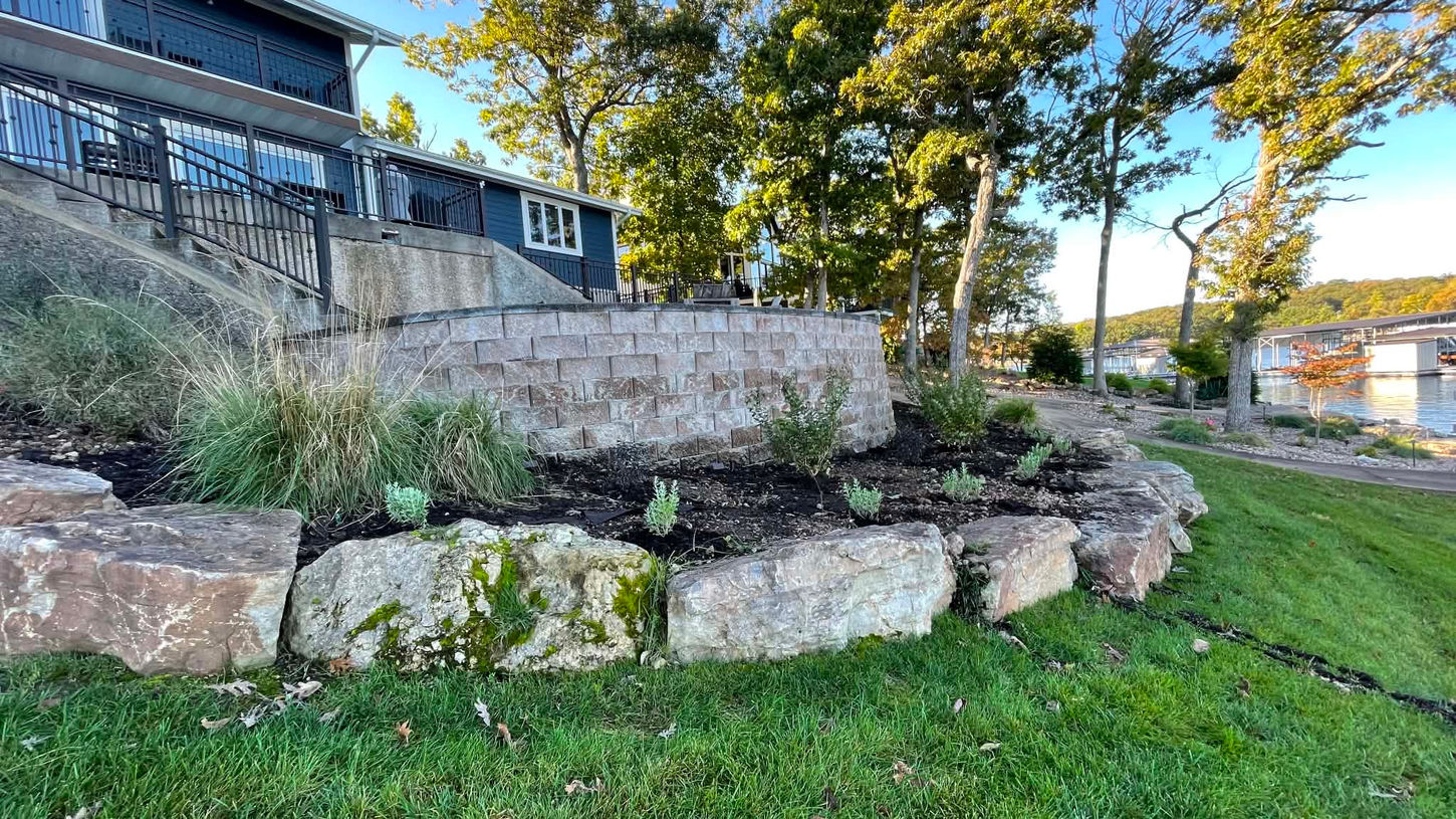 Custom hardscaping, featuring rock work in a circular shape along a tiered yard.