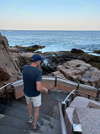 Man walking down staircase to Thunder Hole in Acadia National Park.