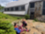 Two women hikers resting in the sun outside the AMC Mitzpah Springs Hut.