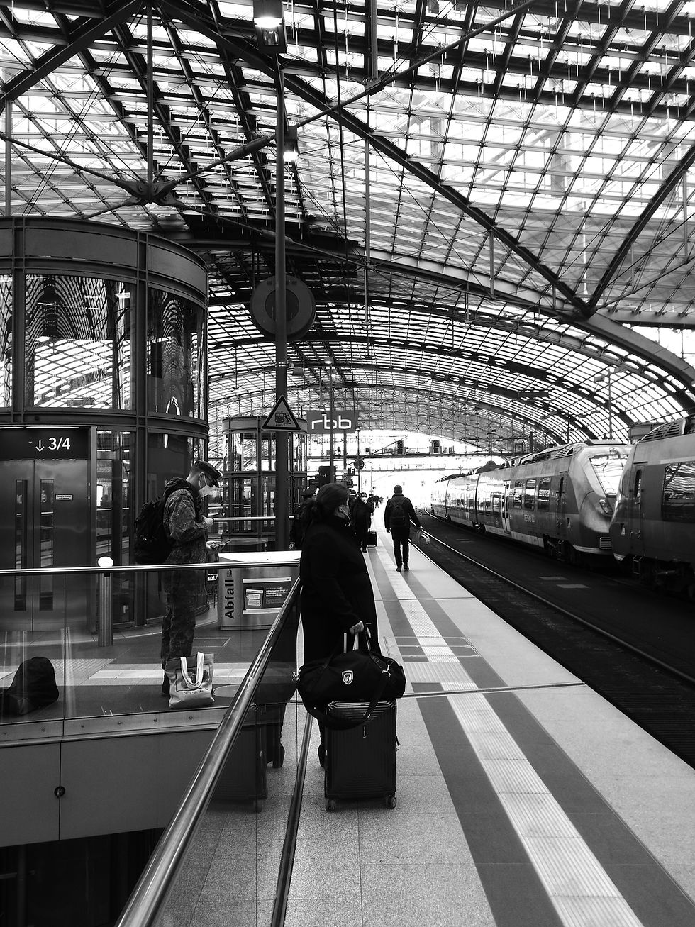 Ein Bundeswehrsoldat in Uniform wartet zwischen anderen Fahrgästen am Berliner Hauptbahnhof