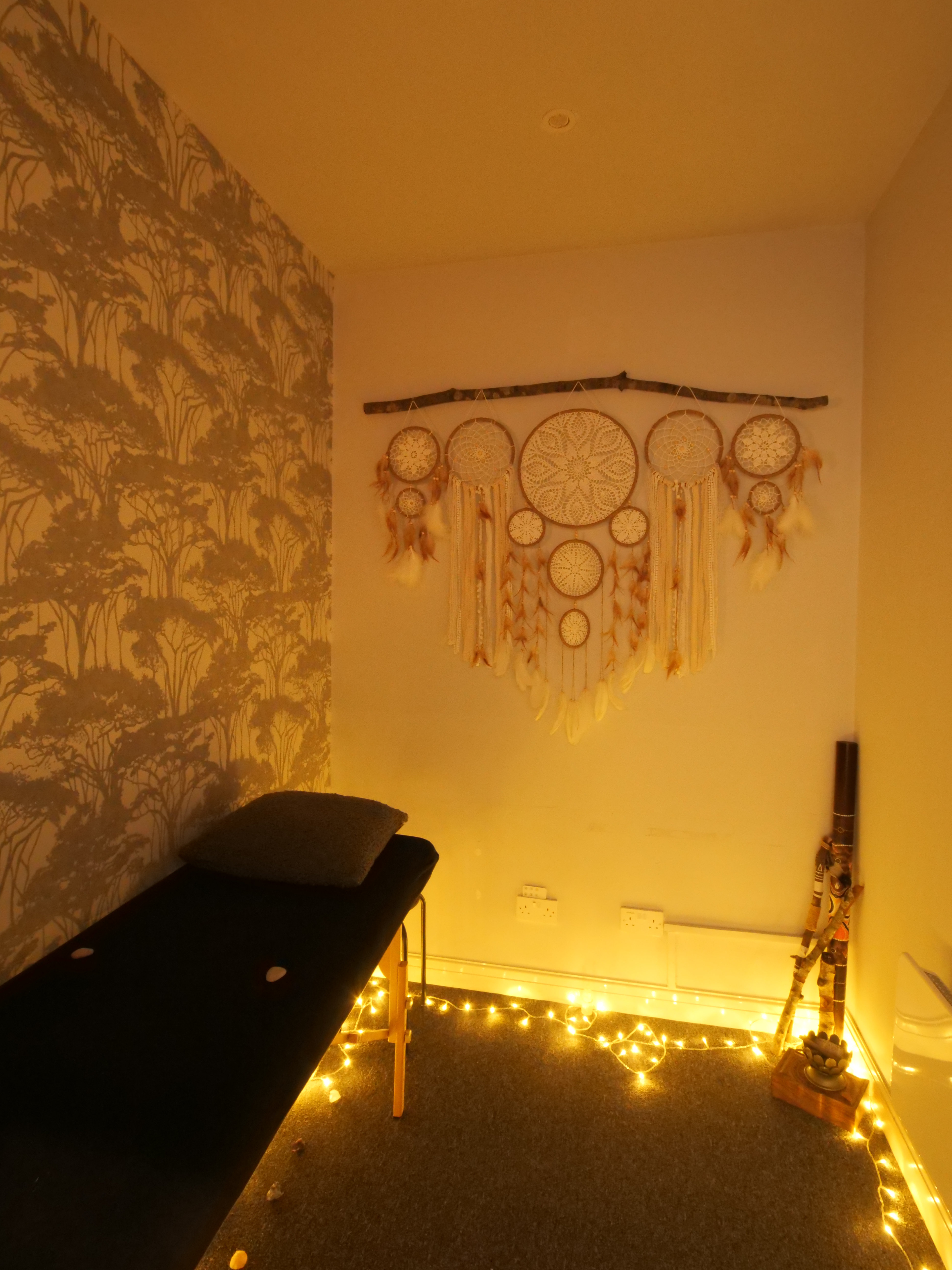 A cozy and tranquil holistic therapy room with warm lighting and soft textures.