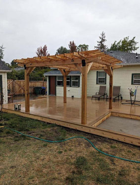 Composite backyard deck with pergola cover attached to house
