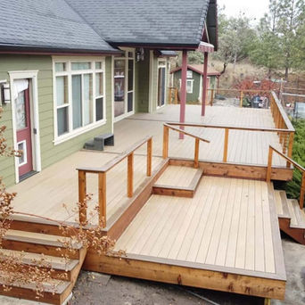 Wood deck with stairs and railing attached to house
