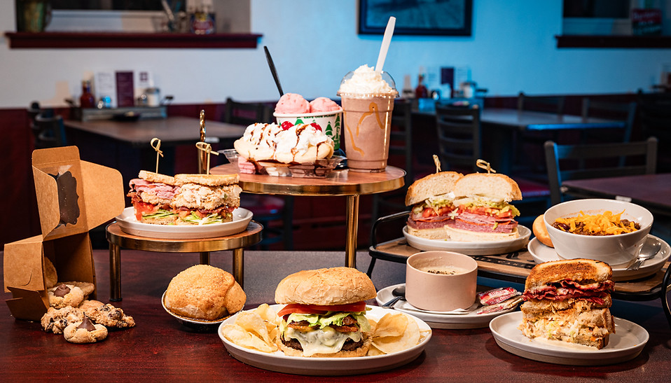 A bacon cheeseburger, club sandwiches, soup, a grilled Reuben, a banana split, ice cream, and a milkshake.