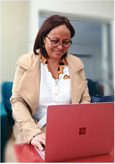 Photo of Brigitte, a former Konexio learner, using a computer.