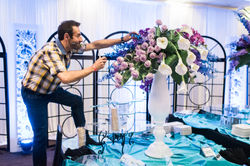 Joe Mineo puts the finishing touches on a floral centerpiece.