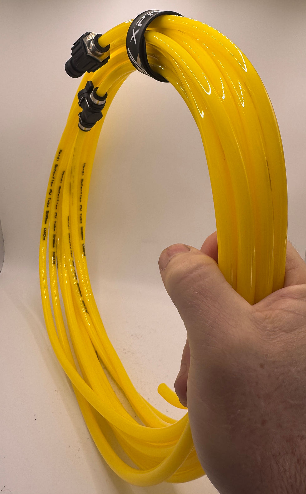 yellow hose held in hand, kept neatly together with snap wrap