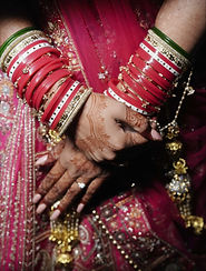 Bride in yellow traditional attire and groom in matching yellow kurta facing each other outdoors — wedding portrait, colorful