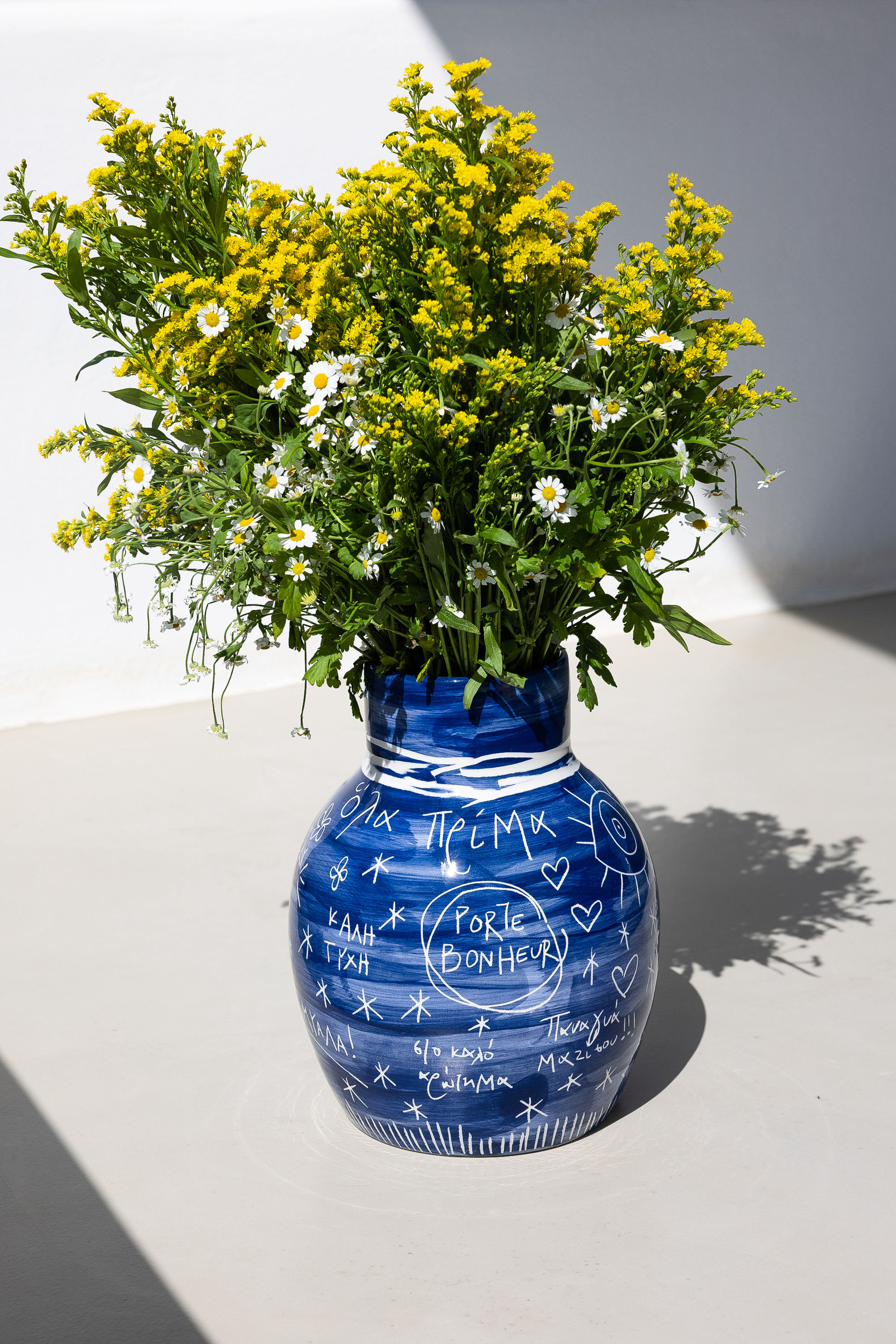 TO VAZO ME TIS EUXES • blue vase