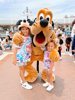 boy and girl with pluto character at tokyo disney