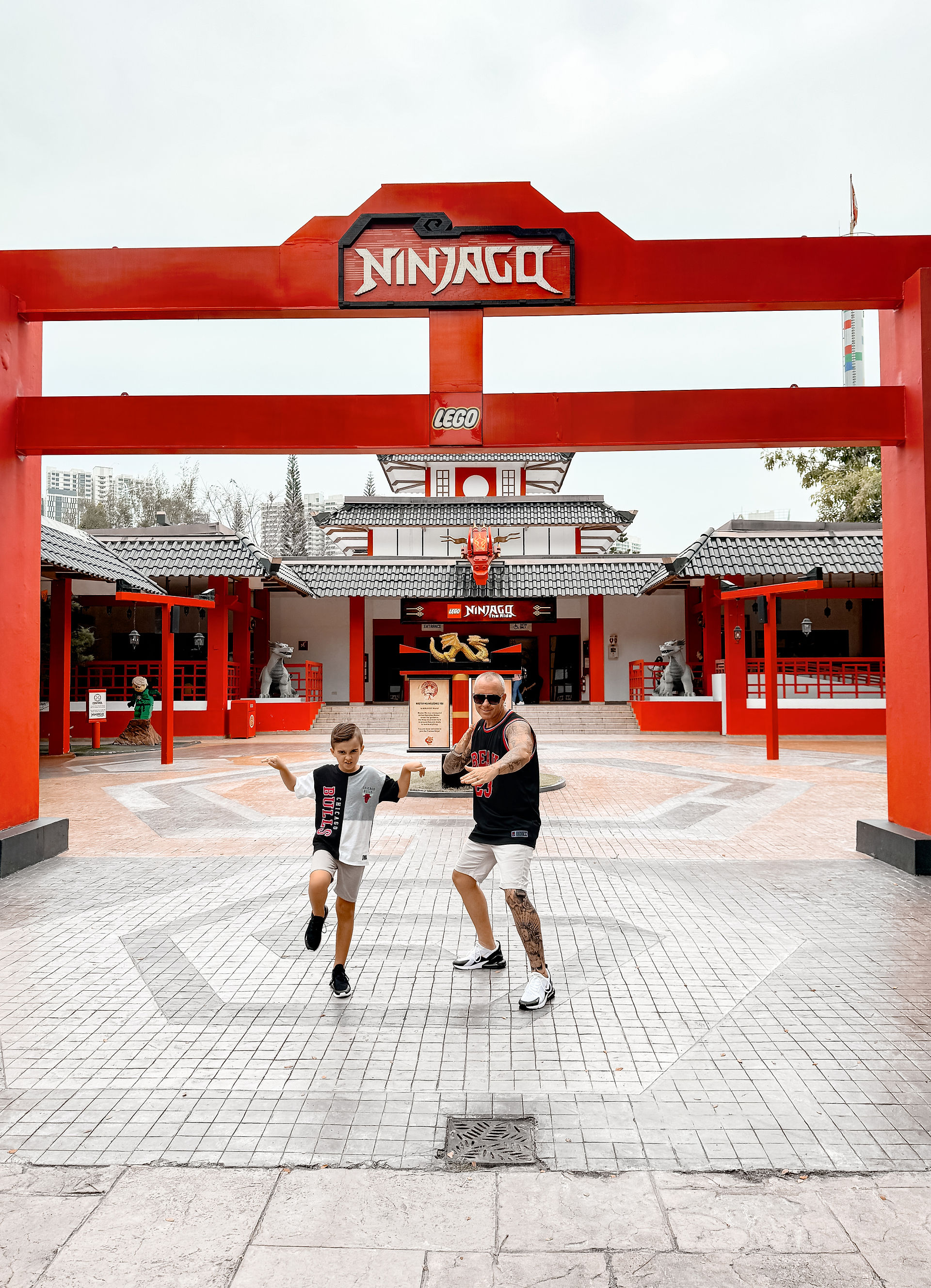 man and boy in front of ninjago sign