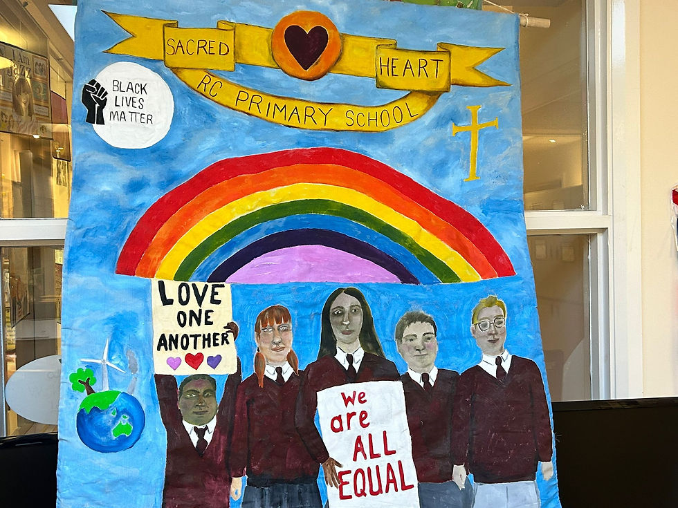 Painting showing five students in school uniforms. Two are holding signs which say 'Love One Another' and 'We are ALL EQUAL'. Above them is rainbow and a yellow banner with 'Sacred Heart RC Primary School'. To the bottom left is a world globe with a tree and wind turbine. Above is a Black Lives Matter badge.