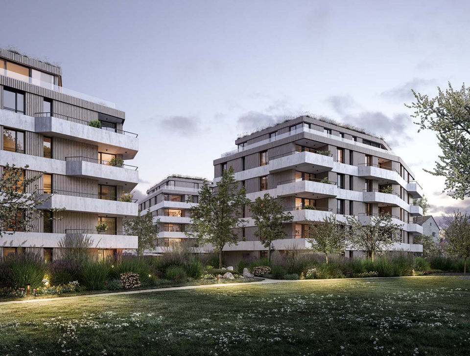 Three housing complexes in dusk setting with a green lawn in the front.