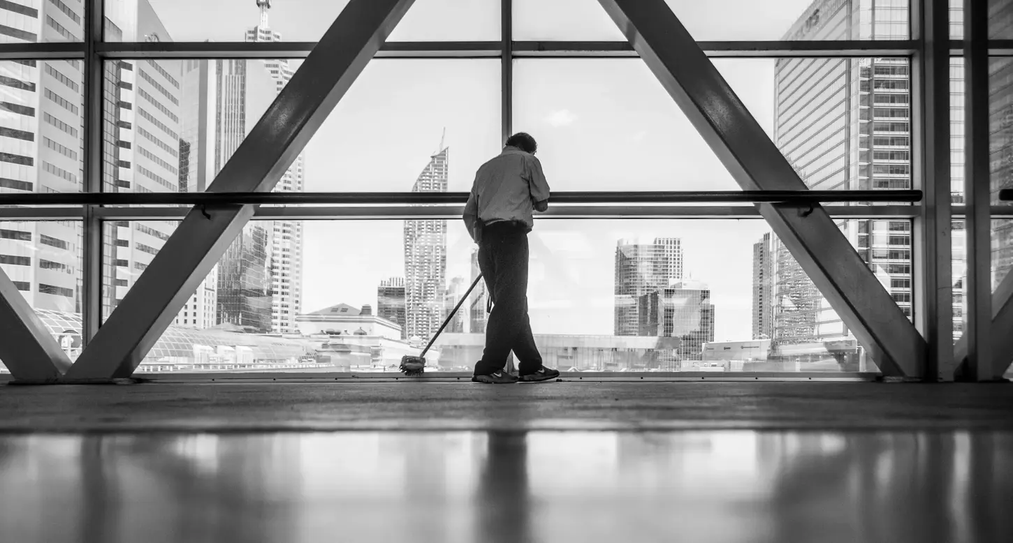 Cityscape & Street Fine-Art Photography by Blake Ferguson demonstrate a monochrome perspective of a custodian sweeping an interior in Downtown Toronto, Ontario, Canada.