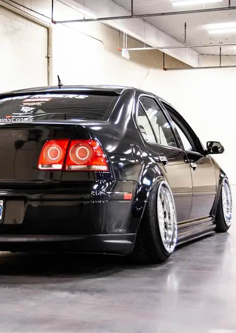 Black Volkswagen Jetta with license plate BNYP-633 parked in empty garage