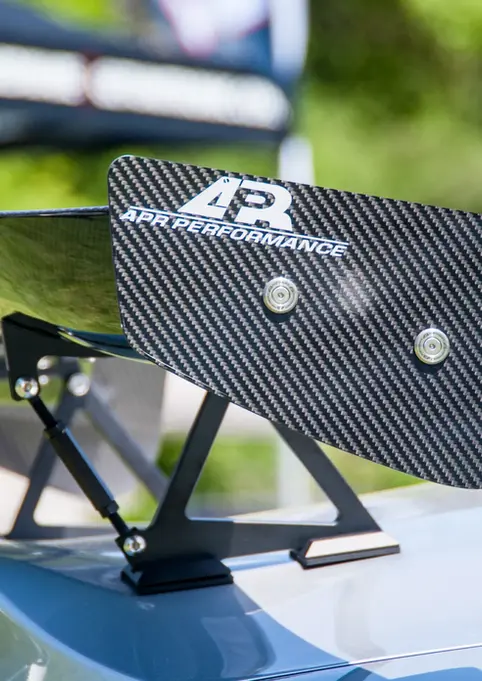 Carbon fiber JAYPERFORMANCE car spoiler mounted on a white vehicle.