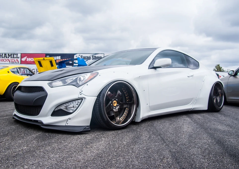 White modified Hyundai Genesis Coupe, lowered stance, custom widebody kit.