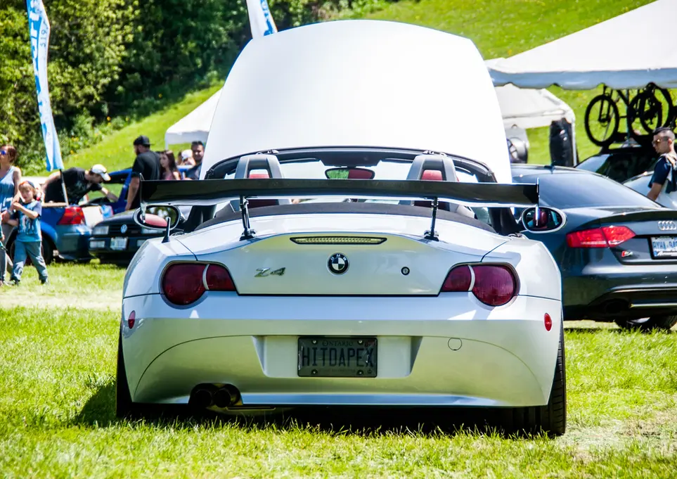 Silver BMW Z4 convertible, "GTO4AFE" license plate, large rear spoiler.
