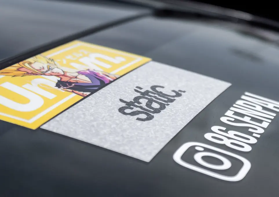 Car hood displaying 'Unsan', 'static.', '86 SENPAI' and Instagram decals.