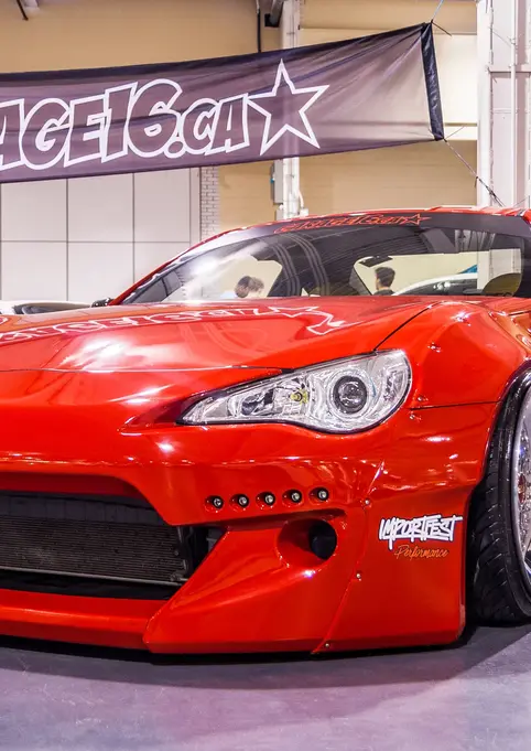 Red modified Toyota 86, GARAGE16.CA banner, displayed at show.
