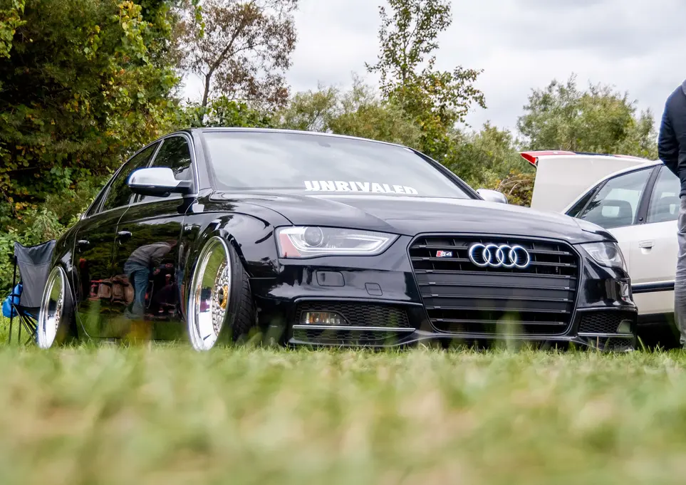 Black Audi sedan with the word Unrivaled at the car show