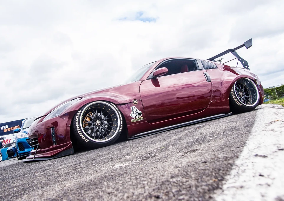Dark red custom Nissan 350Z widebody, slammed on track.