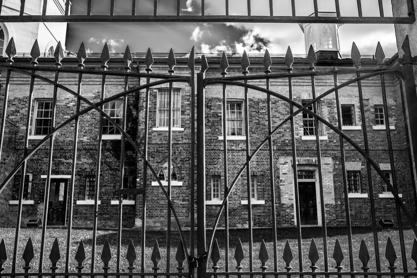 Cityscape & Street Fine-Art Photography by Blake Ferguson demonstrate a monochrome perspective of the gated exterior of the Middlesex County Courthouse, London, Ontario, Canada.