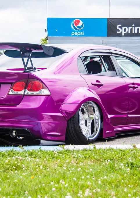 Lowered purple Honda Civic sedan, large rear spoiler, Sprint, Pepsi.