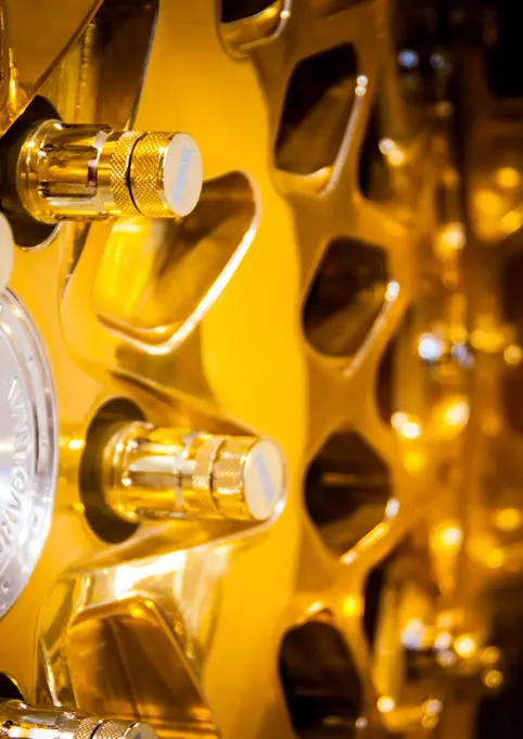 Intricate golden machinery with silver circular design and metallic connectors.