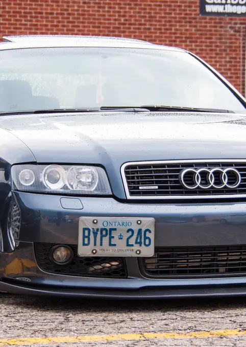 Dark grey Audi A4 with TYPE - 246 license plate, lowered suspension.