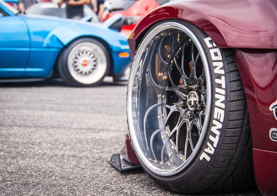 Maroon car wheel with chrome rims and "CONTINENTAL" tire text.