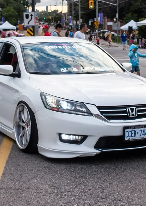 Modified white Honda Accord sedan, CAVV-316 plate, low stance, street event.