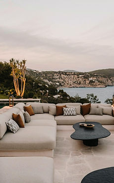 Villa terrace with lounge seating overlooking a Mediterranean harbor