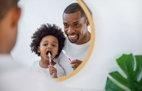 Portrait of happy family black African American father and son child boy brushing teeth in