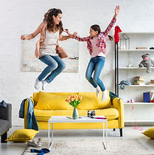 mother-daughter-jumping-living-room.jpg