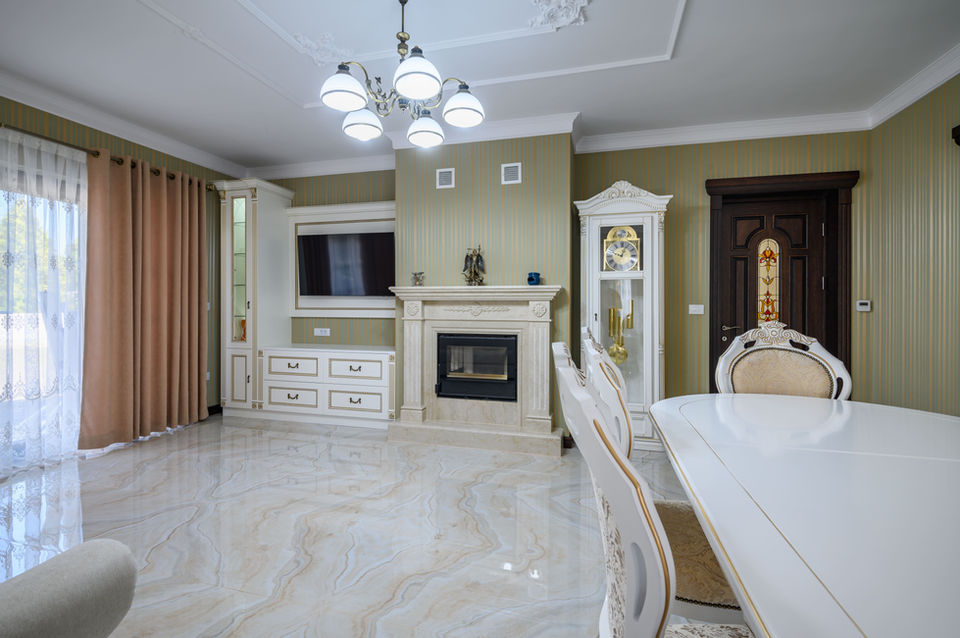 Classic living and dining room with glossy beige marble tile flooring, ornate furniture, and gold-accented décor, creating a luxurious and timeless interior.