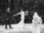 Couple de mariés se tenant la main et se regardant à côté d'une fontaine. Photo en noir et blanc.