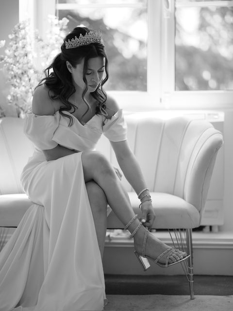 La mariée attache ses chaussures - Photo en noir et blanc